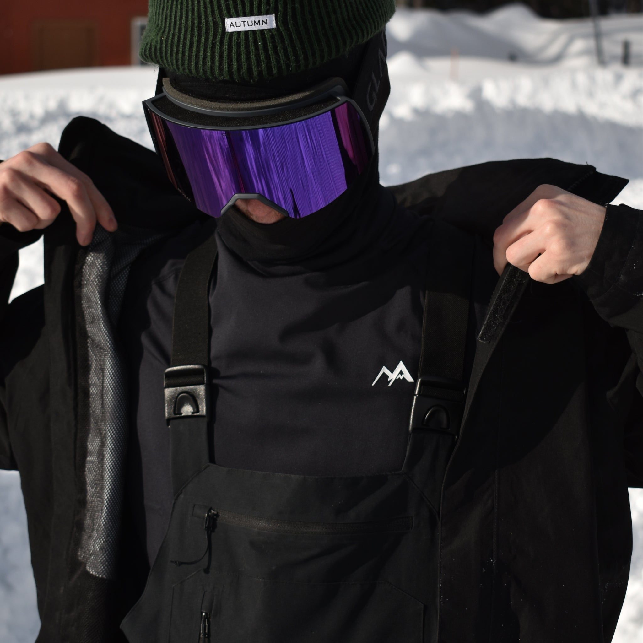 Model standing in the snow wearing Arctic Eco-Sno Men's Base Layer Top in Black.