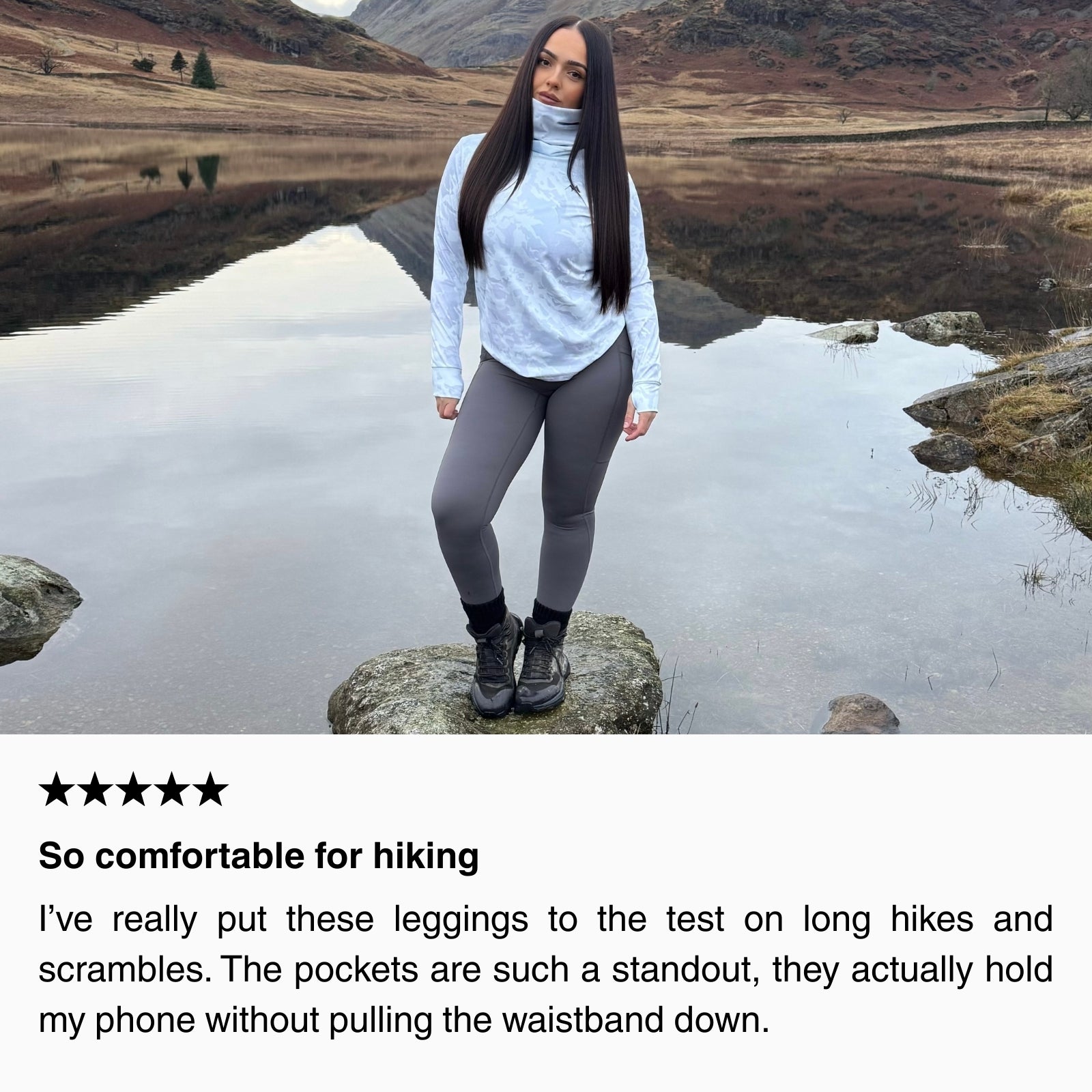 Customer wearing women’s hiking leggings and long-sleeve thermal top standing on a rock beside a mountain lake, showcasing comfortable fit and stretch for hiking and scrambles.