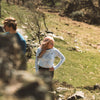 Woman standing on hill hiking in Arctic Eco-Sno Women's Base Layer Top in Sno-Camo and Women's Hiking Leggings in Black.