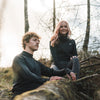 Man and Woman sitting on tree trunk mid-hike wearing Arctic Eco-Sno Base Layers in Black.