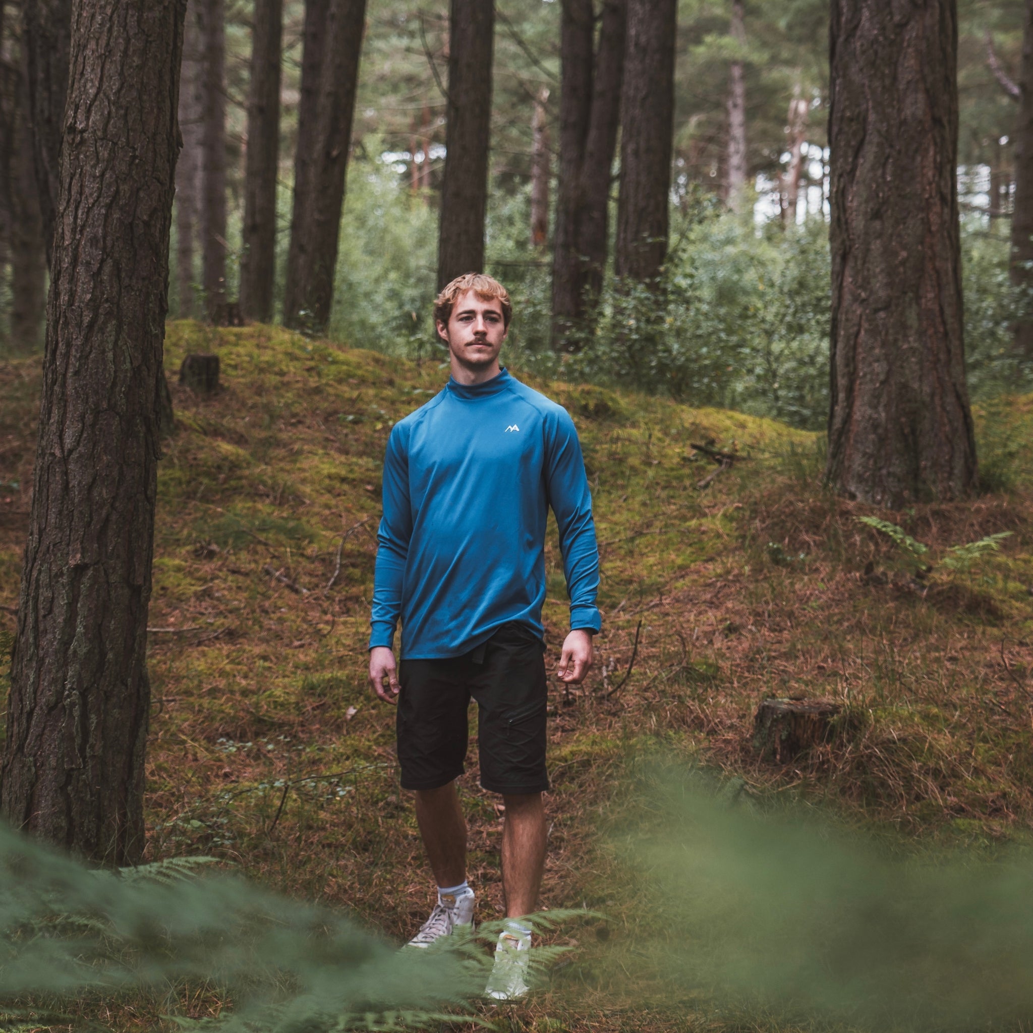 Male wearing Arctic Eco-Sno Men's Midnight Blue Base Layer Top in forest