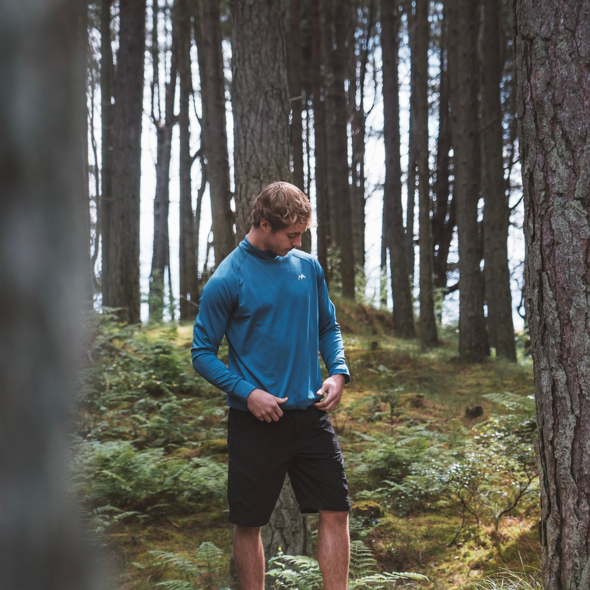 Male wearing Arctic Eco-Sno Men's Midnight Blue Base Layer Top in forest