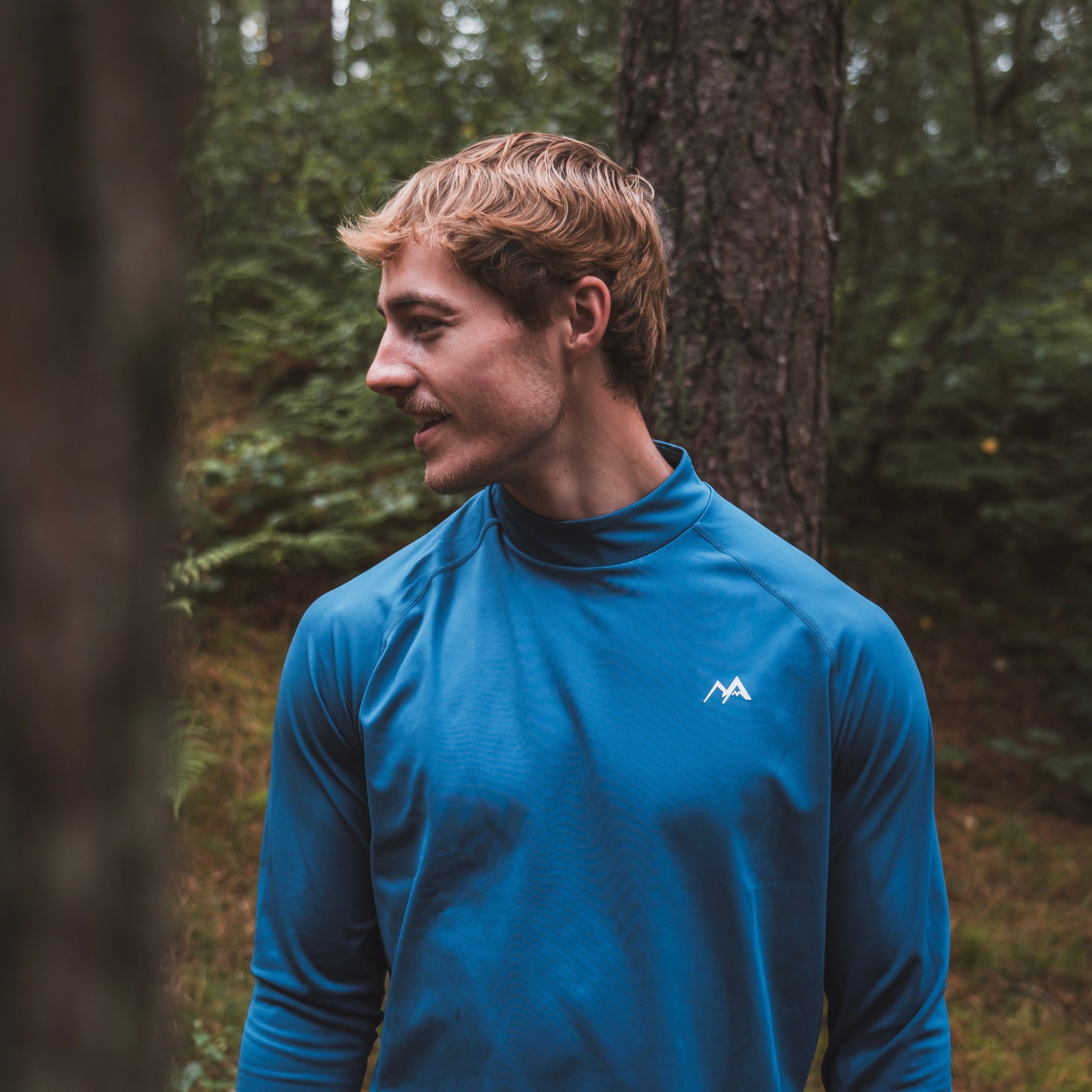 Male wearing Arctic Eco-Sno Men's Midnight Blue Base Layer Top in forest