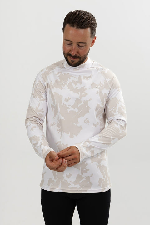 Man wearing Alpine Grey men's thermal ski base layer top, adjusting the sleeve to show the long-sleeve fit and camouflage pattern.