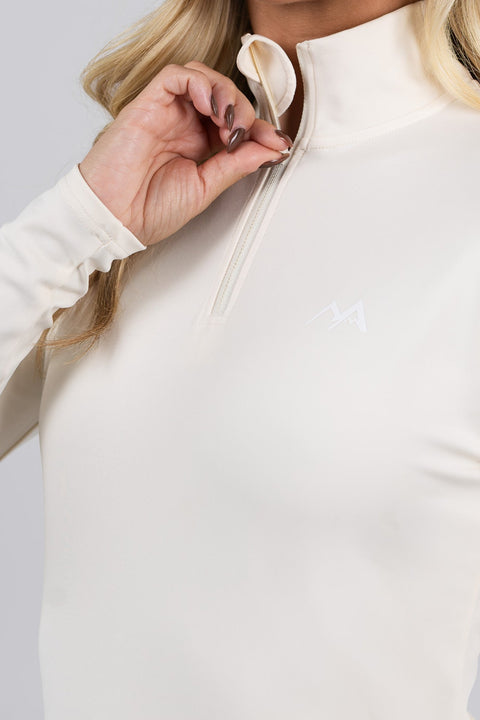 Close-up of women's Buttercream quarter zip thermal ski top showing the zip fastening, high collar, chin guard and white mountain logo.