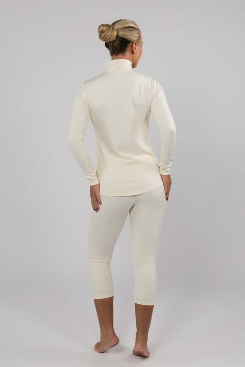 Full-length back view of women's Buttercream thermal ski base layer top showing its extended curved hem, long sleeves and matching 3/4 leggings.
