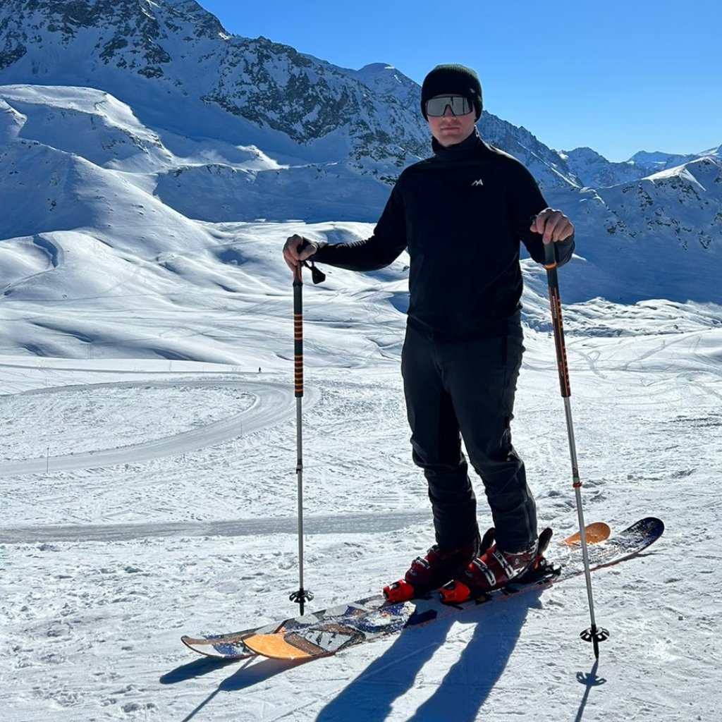 skier in the mountains wearing ski thermal in black