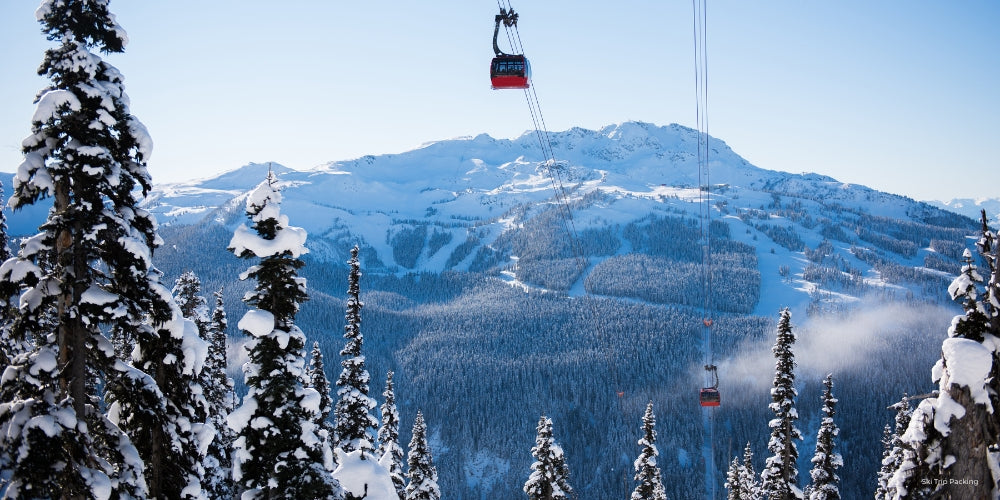 Ski lift with snow-covered trees and mountains in the background
