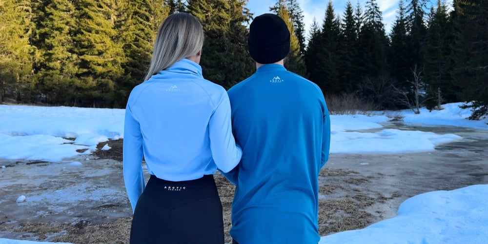 man & women standing in the snow wearing ski thermals