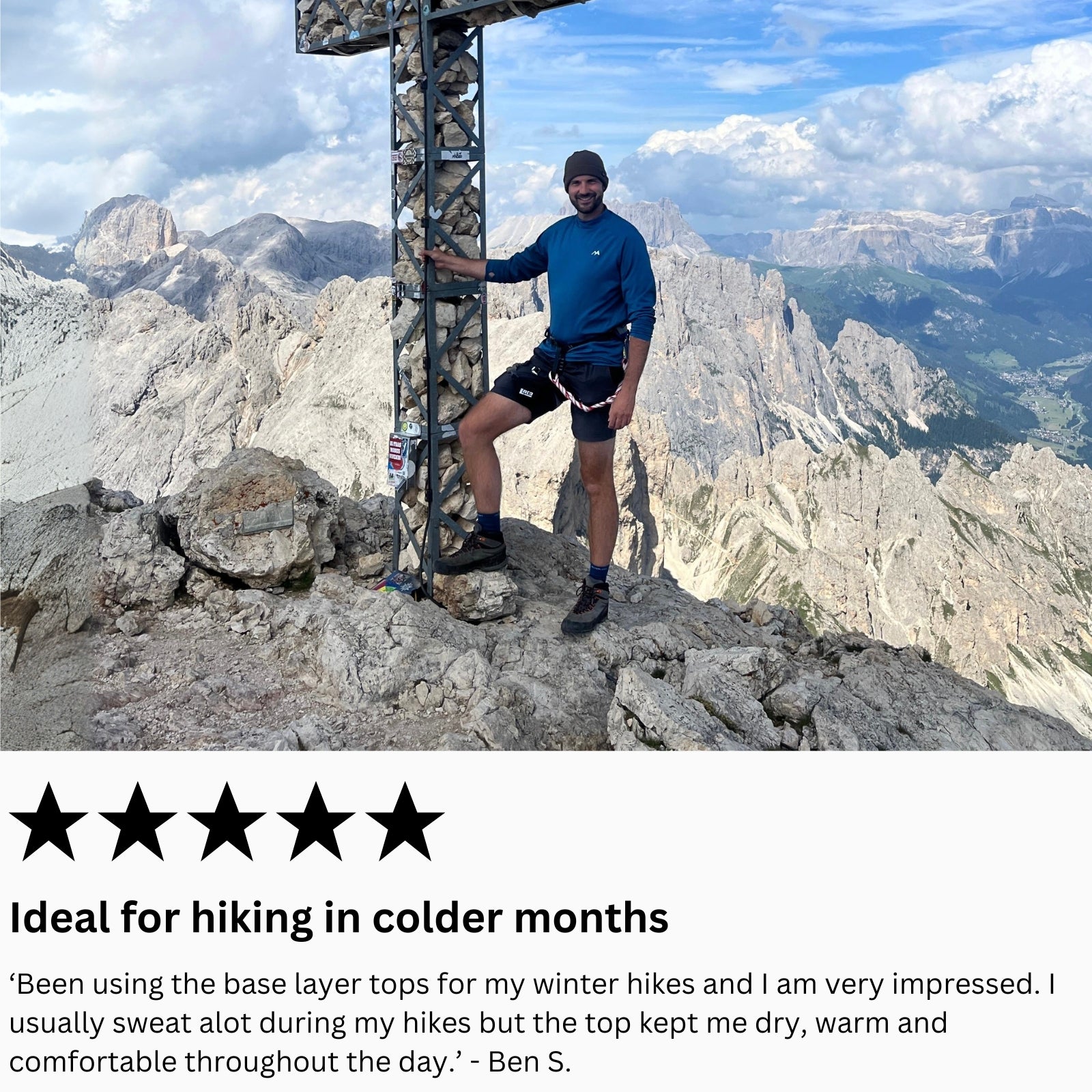 man on a mountain top with hiking equipment, wearing arctic eco sno base layer top surrounded by scenic mountains.