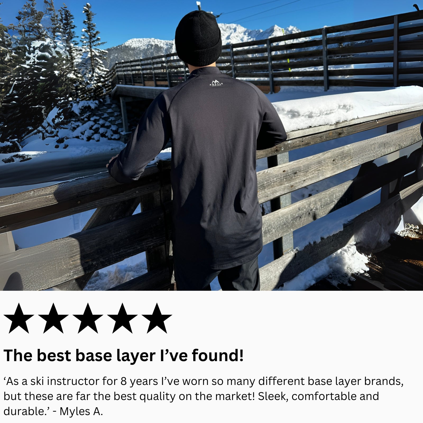 Person wearing a mens black base layer standing on a snowy bridge with mountains in the background