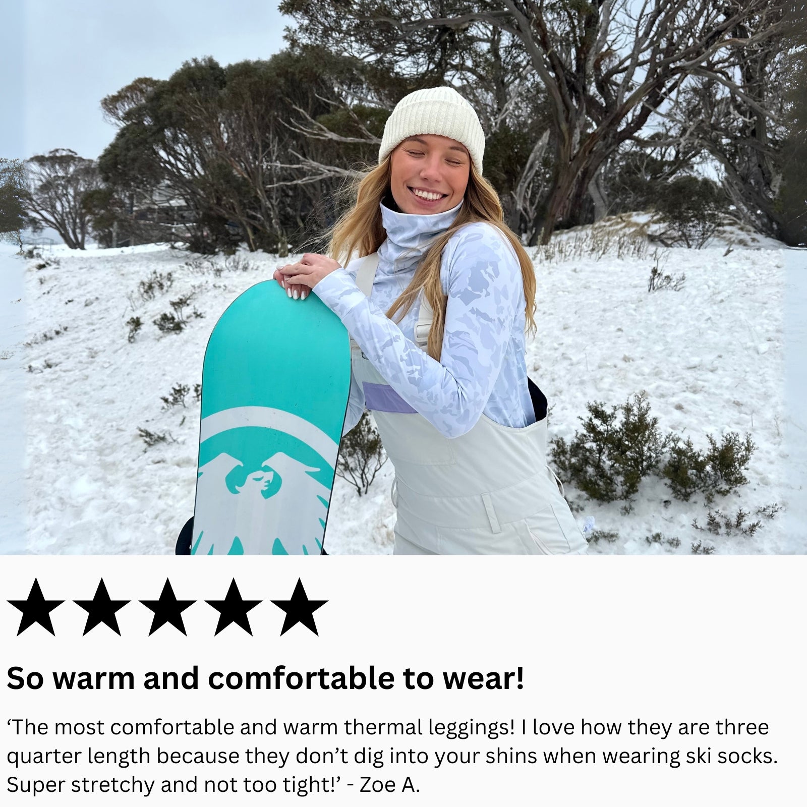 Woman holding a snowboard in a snowy landscape wearing sno-camo base layer top