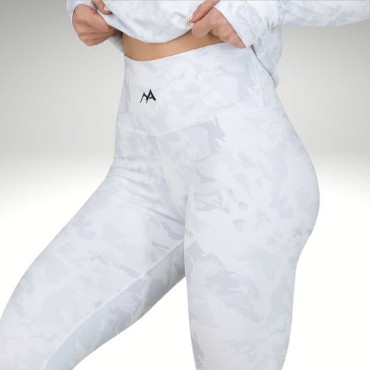 Woman showing elasticated waist band in snow-camo women's base layers.