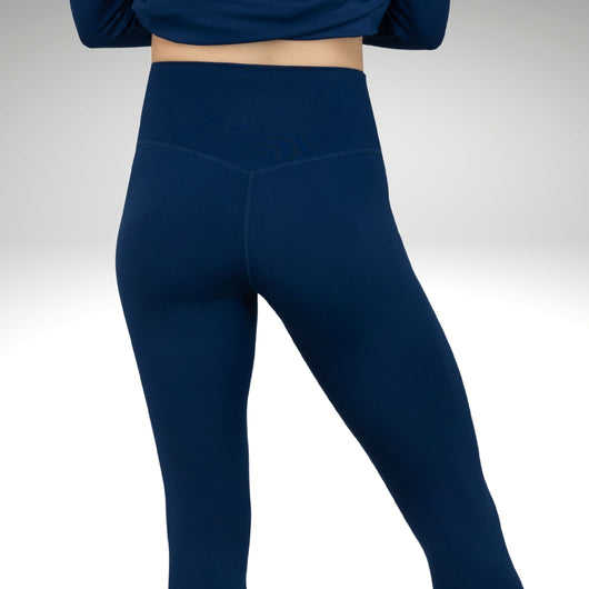 Female model wearing blue base layers featuring compressed and supportive fabric.