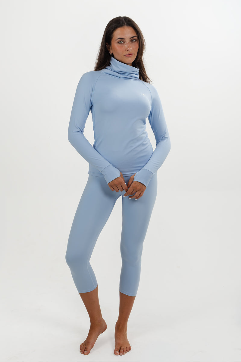 Women wearing Sky Blue high neck thermal ski base layer top with matching 3/4 leggings.