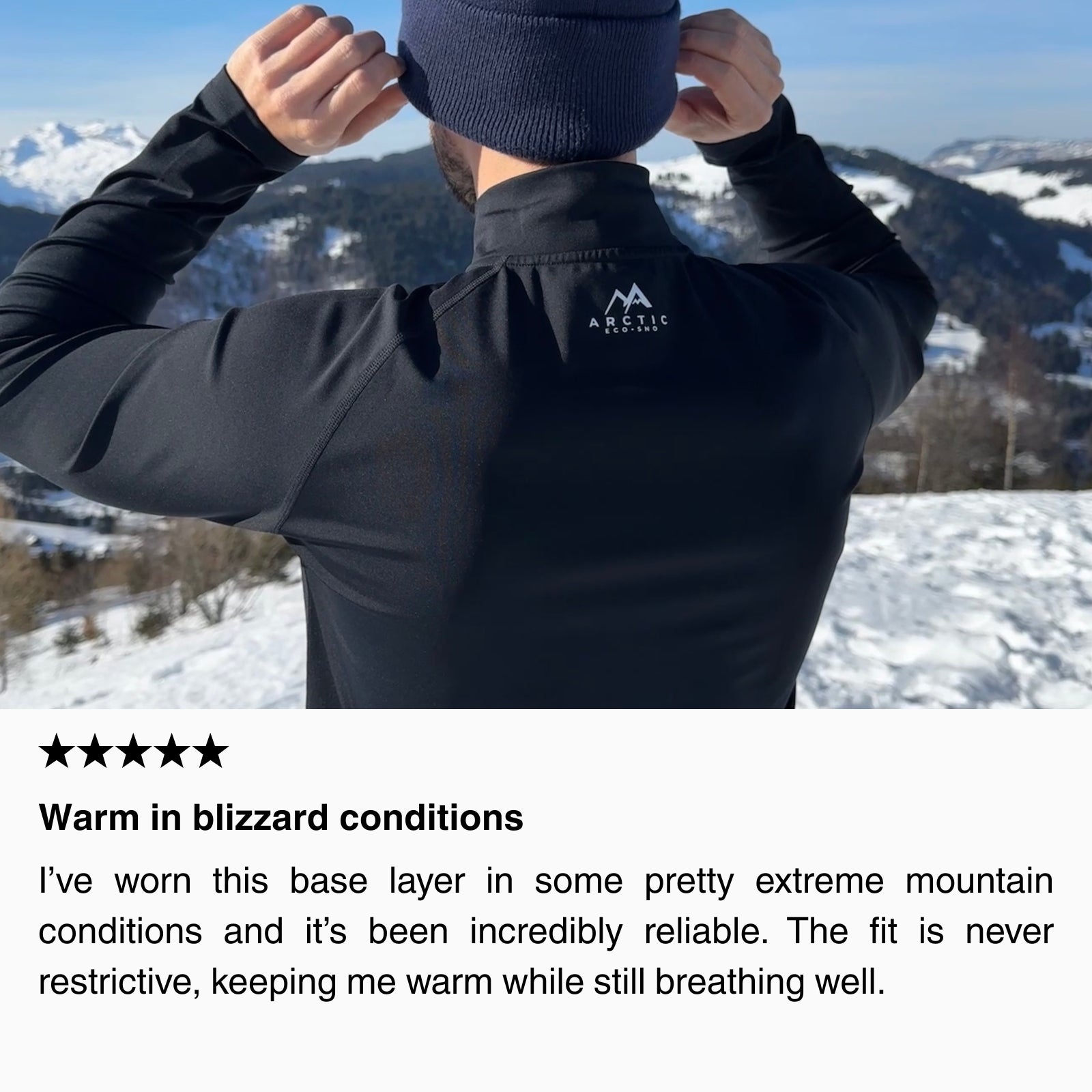 Customer wearing a black thermal ski base layer adjusting a beanie on a snowy mountain, showing a close-fitting, breathable base layer designed to keep skiers warm in extreme winter conditions.