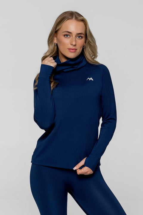 Woman wearing arctic eco sno navy thermal base layer top with grey background.